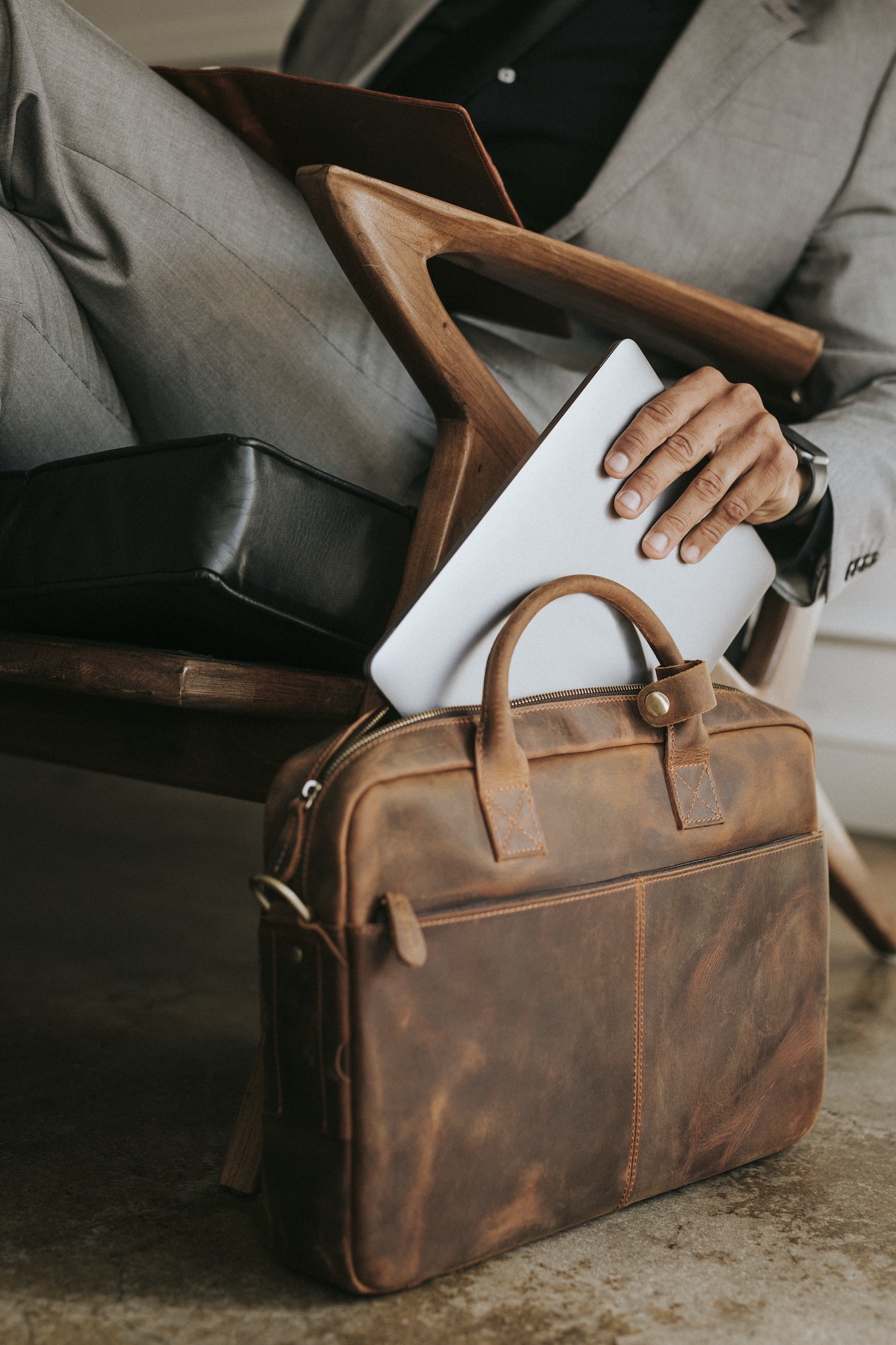 Businessman putting laptop on his bag